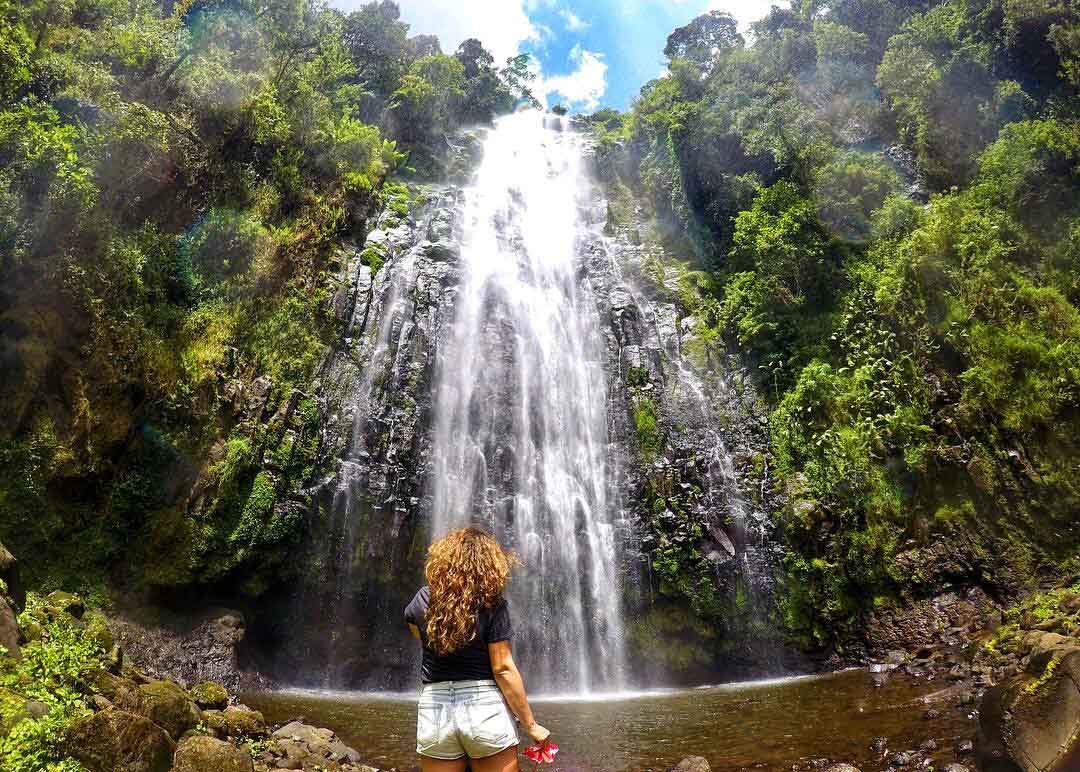 Materuni Waterfall cascading down a lush green cliff